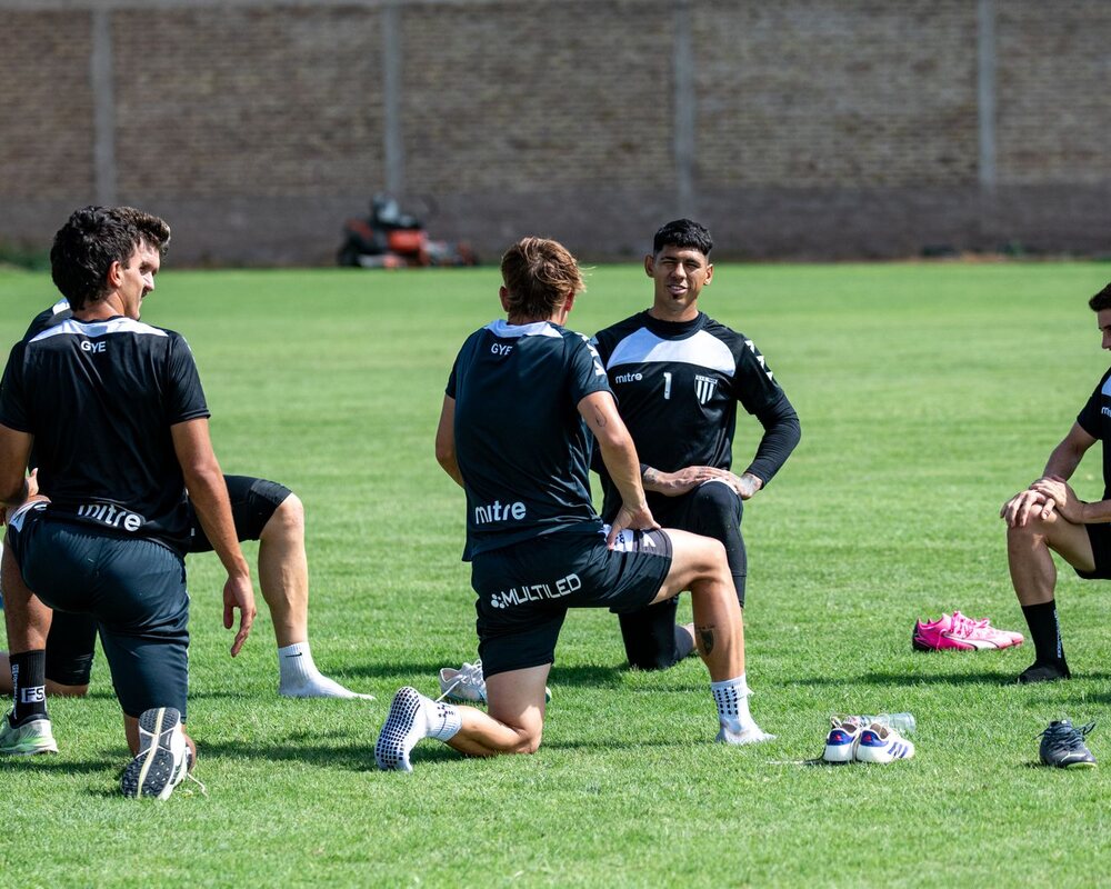 Football squad warming up on a grass field